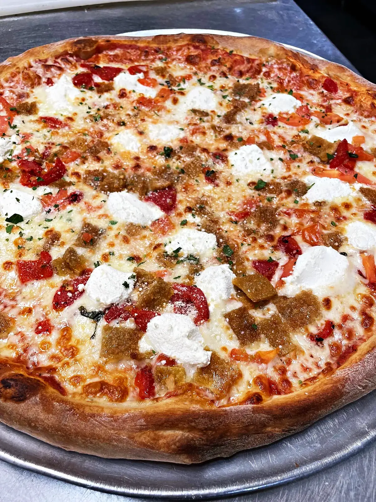 A brick-oven pie with ricotta and sausage