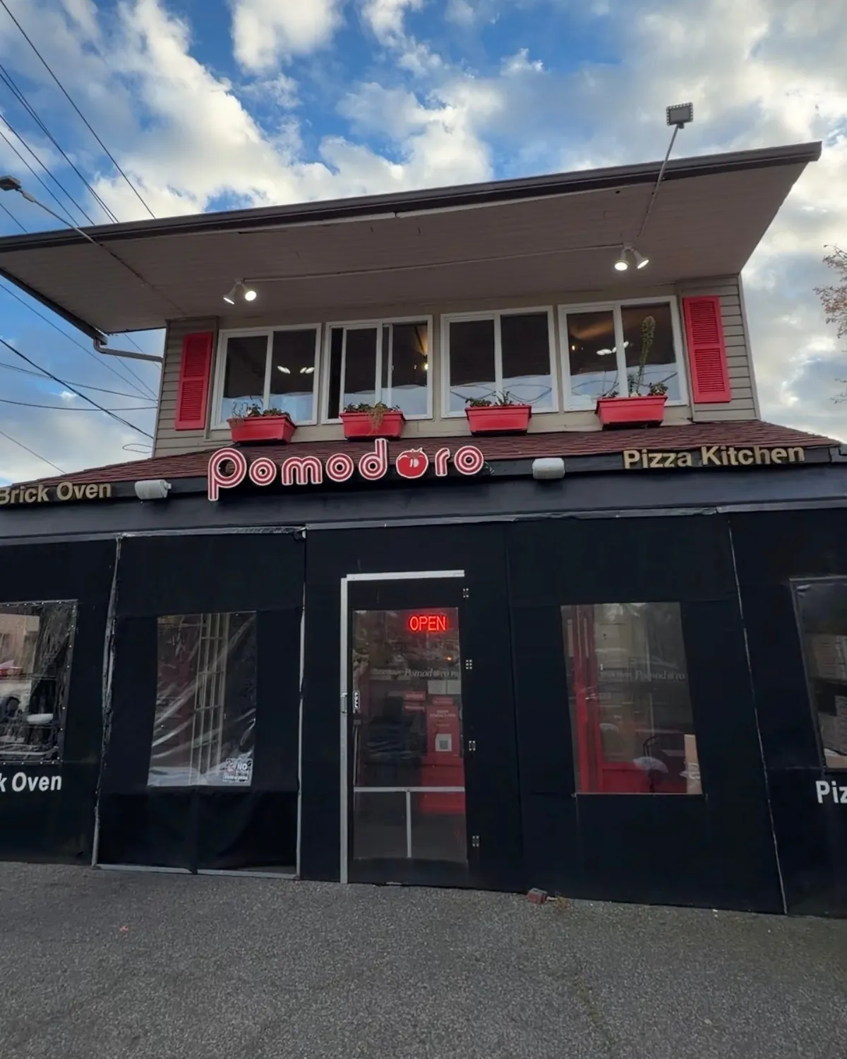 The Pomodoro storefront on Abbott Boulevard, red shutters above the sign