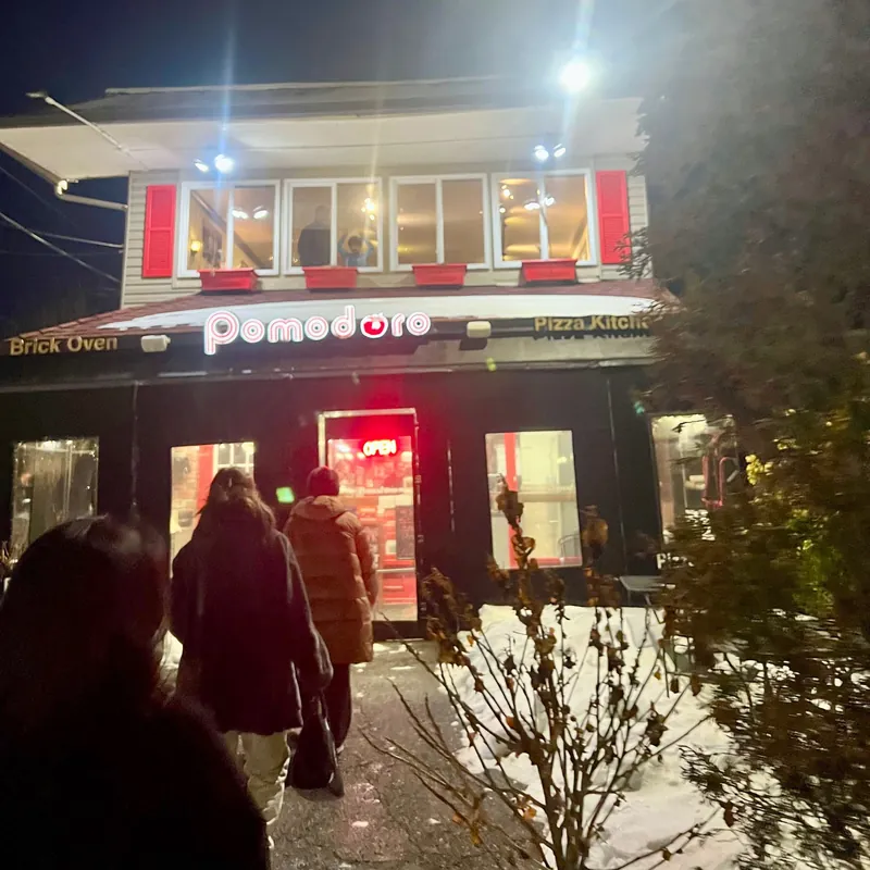 Guests walking up to Pomodoro on a winter night