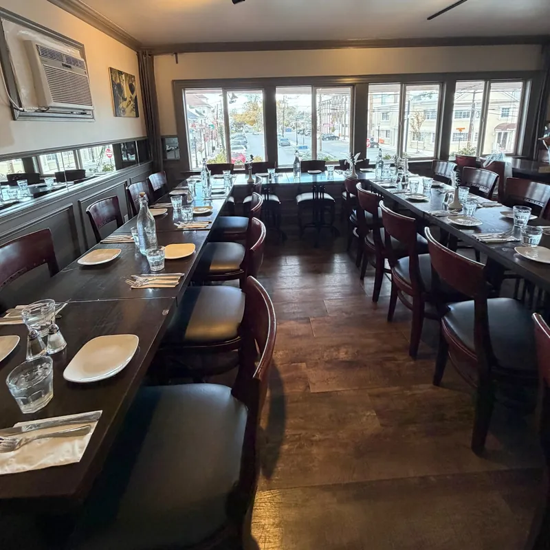 The dining room, tables set beneath a row of windows